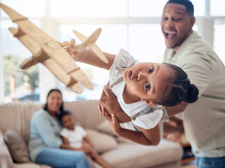 father girl playing with toy airplane in family to celebrate international moving