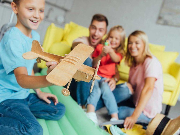 A boy playing with toy airplane, family to celebrate international moving