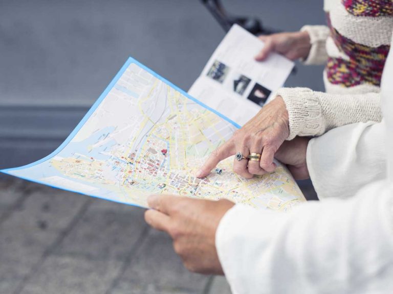 Hands of 2 peoples checking on paper map for city orientation in vietnam