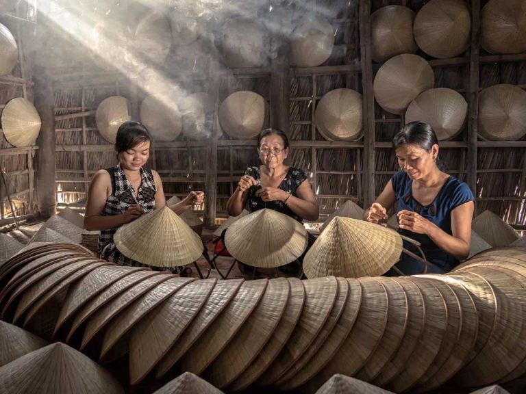 3 local vietnamese artisans making traditional conical hat in for cultural orientation in vietnam