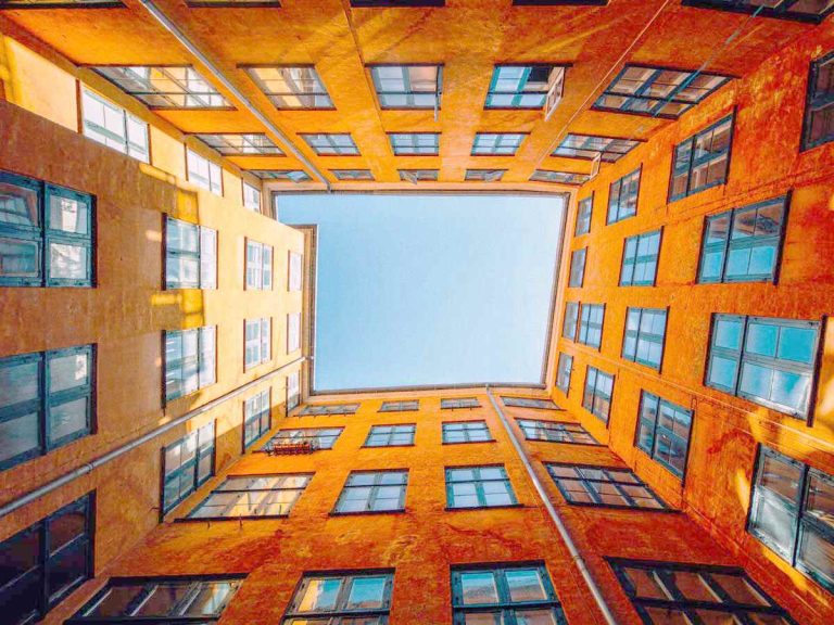low angle shot of a high rise orange building as temporary housing