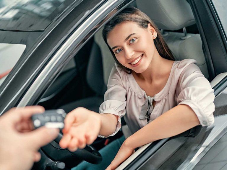 Woman getting her car key and happy and smiling for car leasing service