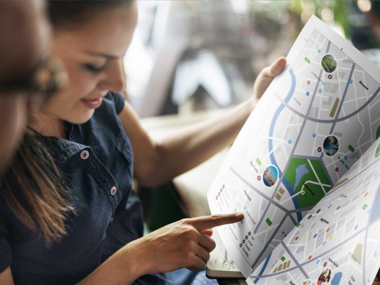 Nice couple looking for itinary on a paper map for city orientation in the philippines