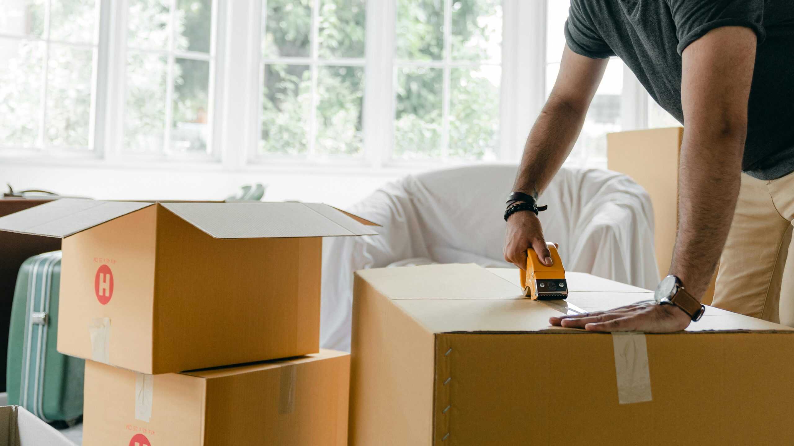 man taping moving boxes