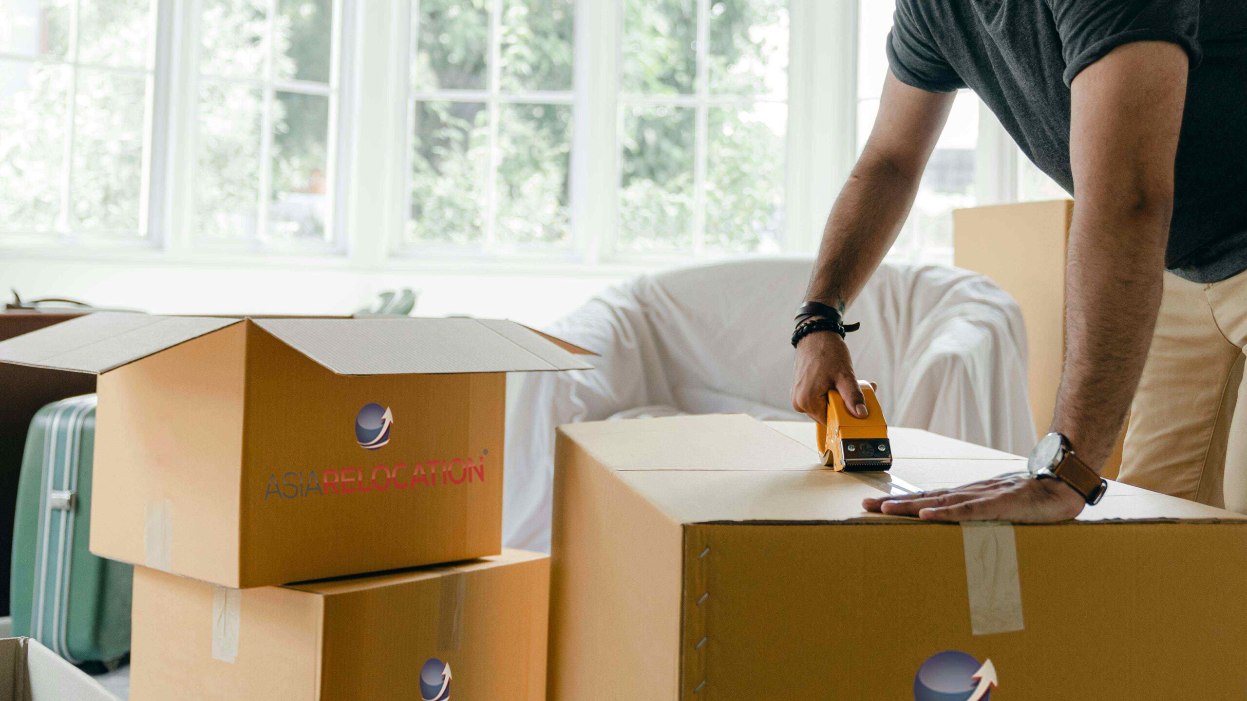 man taping moving boxes